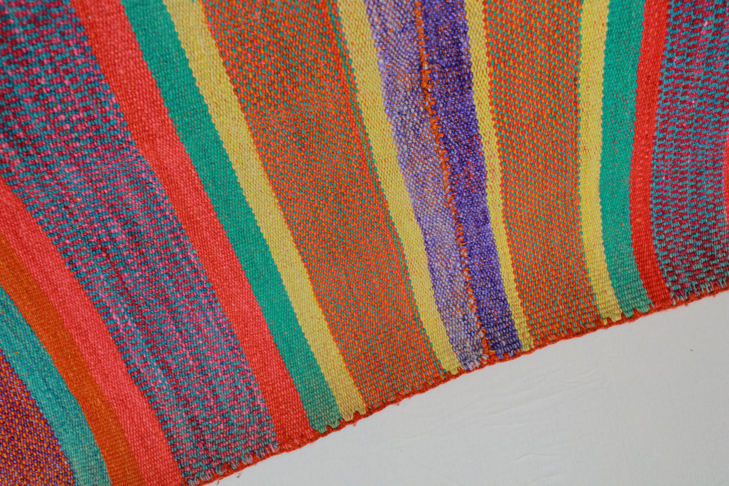 Handgefertigter Frazada-Teppich aus Peru – farbenfroh, traditionell und ideal für Balkon, Terrasse oder gemütliche Wohnräume. Dieser bunte Teppich bringt peruanisches Kunsthandwerk und Wärme in dein Zuhause und setzt lebendige Akzente im Boho- oder Ethno-Stil für drinnen und draußen.