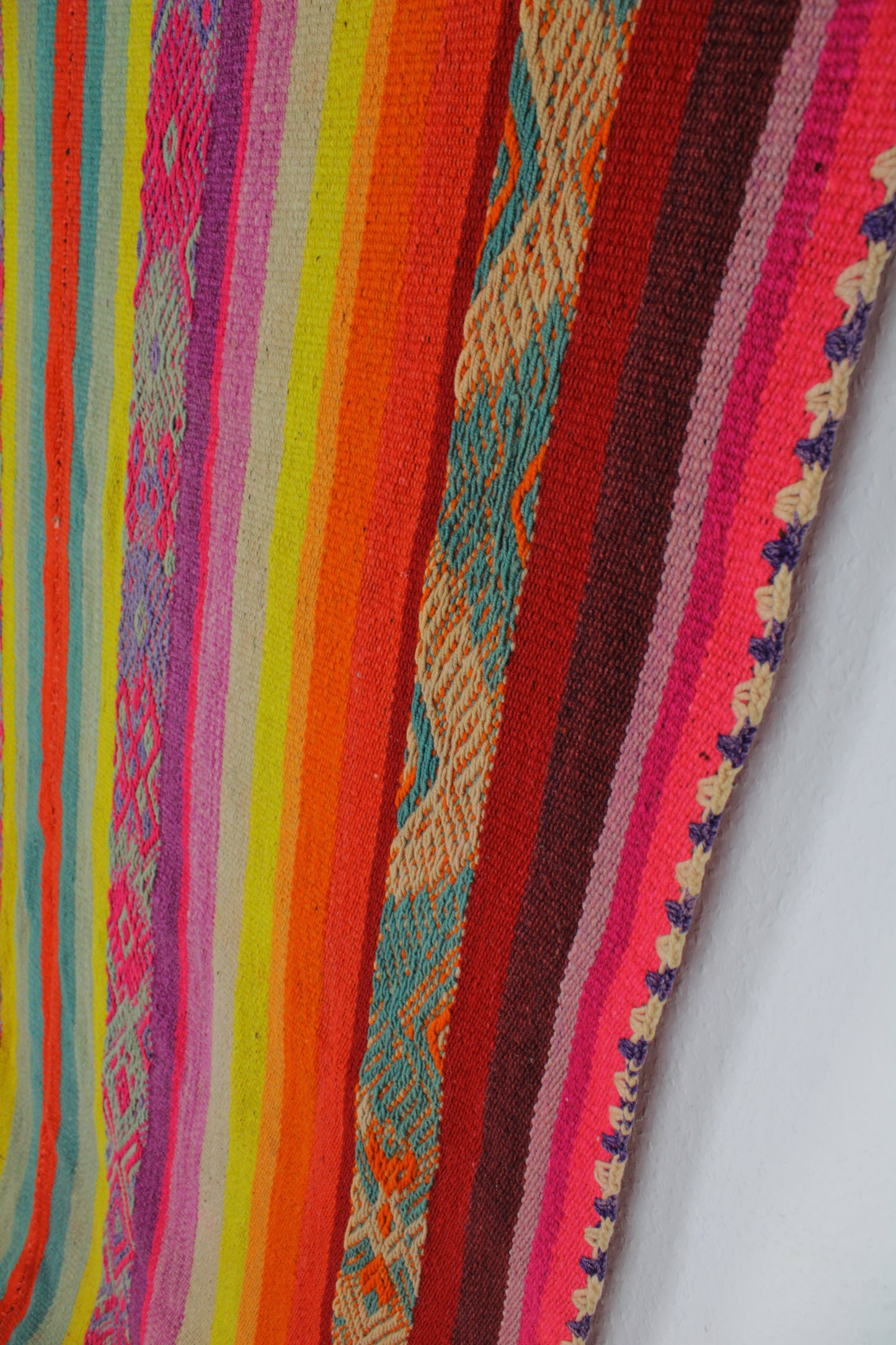 Handgefertigter Frazada-Teppich aus Peru – farbenfroh, traditionell und ideal für Balkon, Terrasse oder gemütliche Wohnräume. Dieser bunte Teppich bringt peruanisches Kunsthandwerk und Wärme in dein Zuhause und setzt lebendige Akzente im Boho- oder Ethno-Stil für drinnen und draußen.