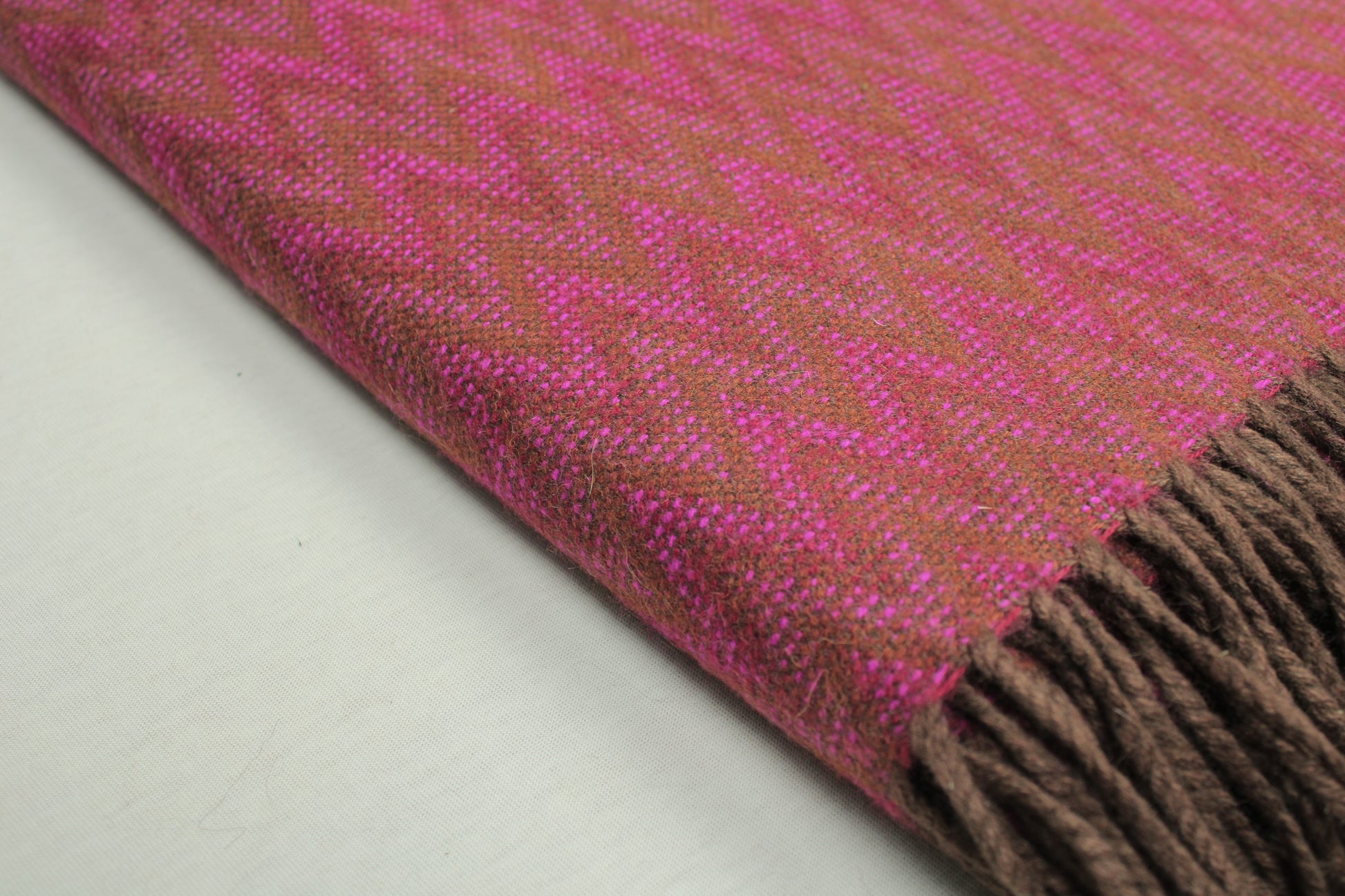 Vergrößerte Ansicht der Webstruktur der weichen Sofadecke aus Alpaka in weinrot
