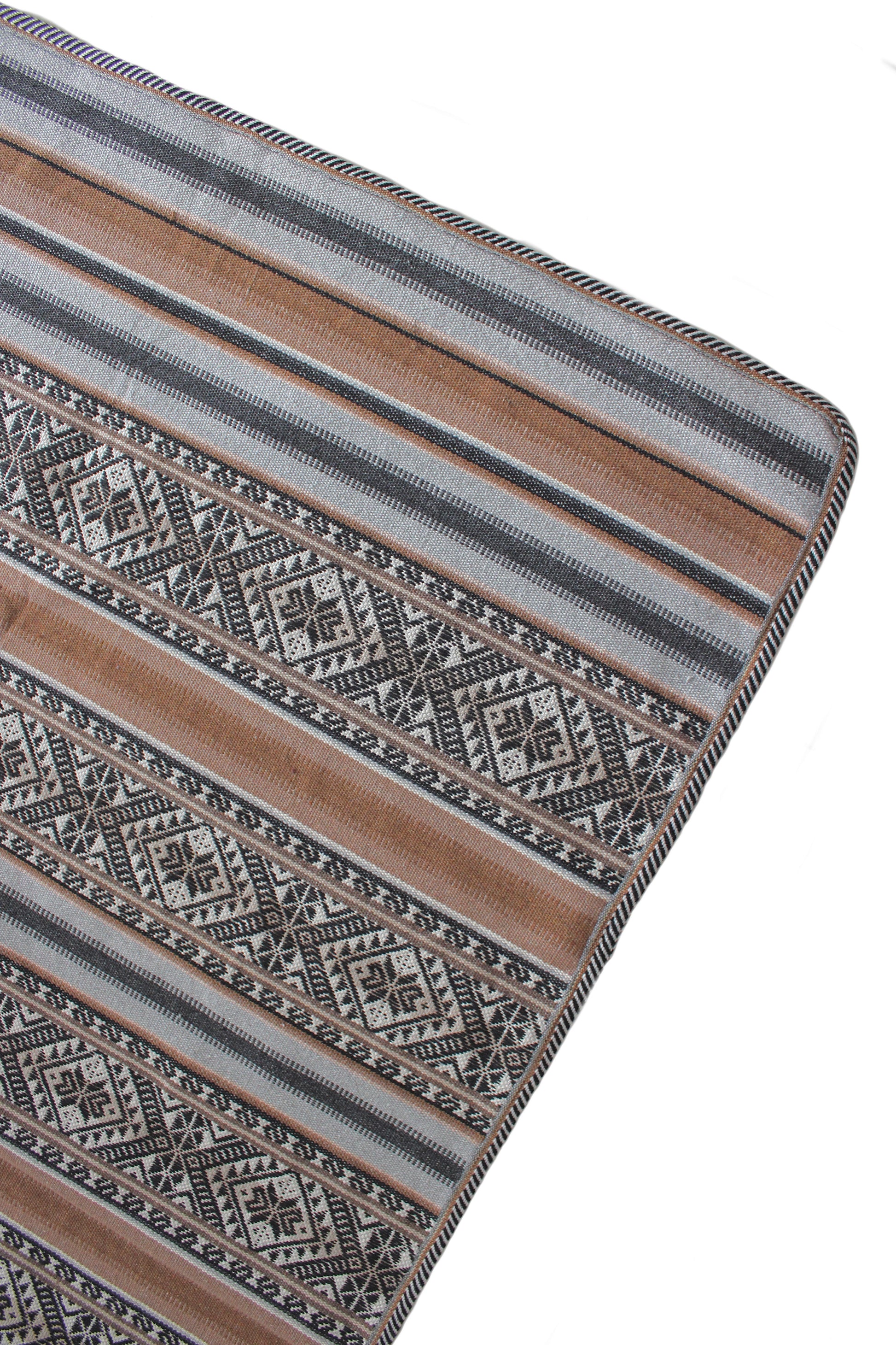 Peruanische Baumwoll-Tagesdecke mit traditionellem Andenmuster in einem modernen, minimalistischen Schlafzimmer. Handgewebtes Kunsthandwerk aus Peru als stilvoller Boho-Wohnakzent.