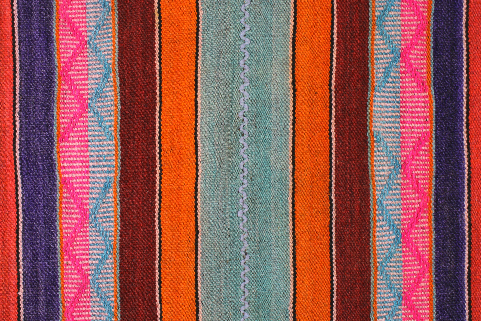 Handgefertigter Frazada-Teppich aus Peru – farbenfroh, traditionell und ideal für Balkon, Terrasse oder gemütliche Wohnräume. Dieser bunte Teppich bringt peruanisches Kunsthandwerk und Wärme in dein Zuhause und setzt lebendige Akzente im Boho- oder Ethno-Stil für drinnen und draußen.