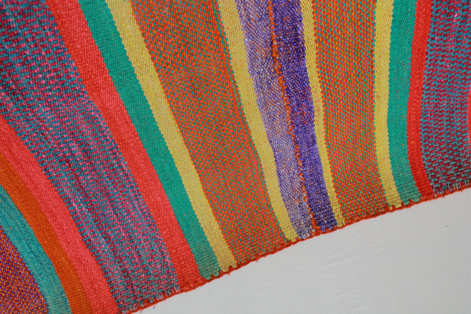 Handgefertigter Frazada-Teppich aus Peru – farbenfroh, traditionell und ideal für Balkon, Terrasse oder gemütliche Wohnräume. Dieser bunte Teppich bringt peruanisches Kunsthandwerk und Wärme in dein Zuhause und setzt lebendige Akzente im Boho- oder Ethno-Stil für drinnen und draußen.