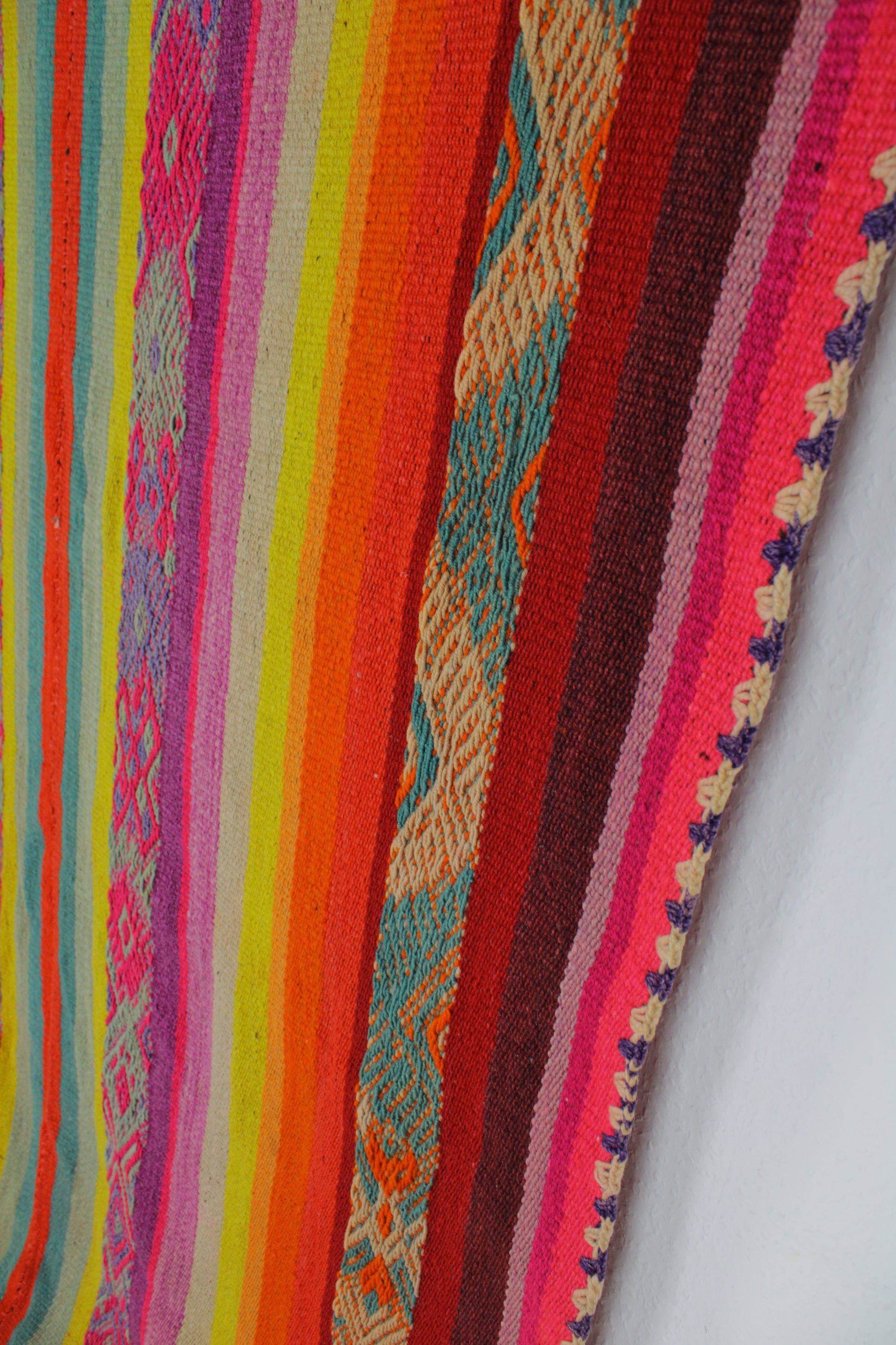 Handgefertigter Frazada-Teppich aus Peru – farbenfroh, traditionell und ideal für Balkon, Terrasse oder gemütliche Wohnräume. Dieser bunte Teppich bringt peruanisches Kunsthandwerk und Wärme in dein Zuhause und setzt lebendige Akzente im Boho- oder Ethno-Stil für drinnen und draußen.
