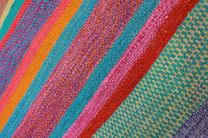 Handgefertigter Frazada-Teppich aus Peru – farbenfroh, traditionell und ideal für Balkon, Terrasse oder gemütliche Wohnräume. Dieser bunte Teppich bringt peruanisches Kunsthandwerk und Wärme in dein Zuhause und setzt lebendige Akzente im Boho- oder Ethno-Stil für drinnen und draußen.