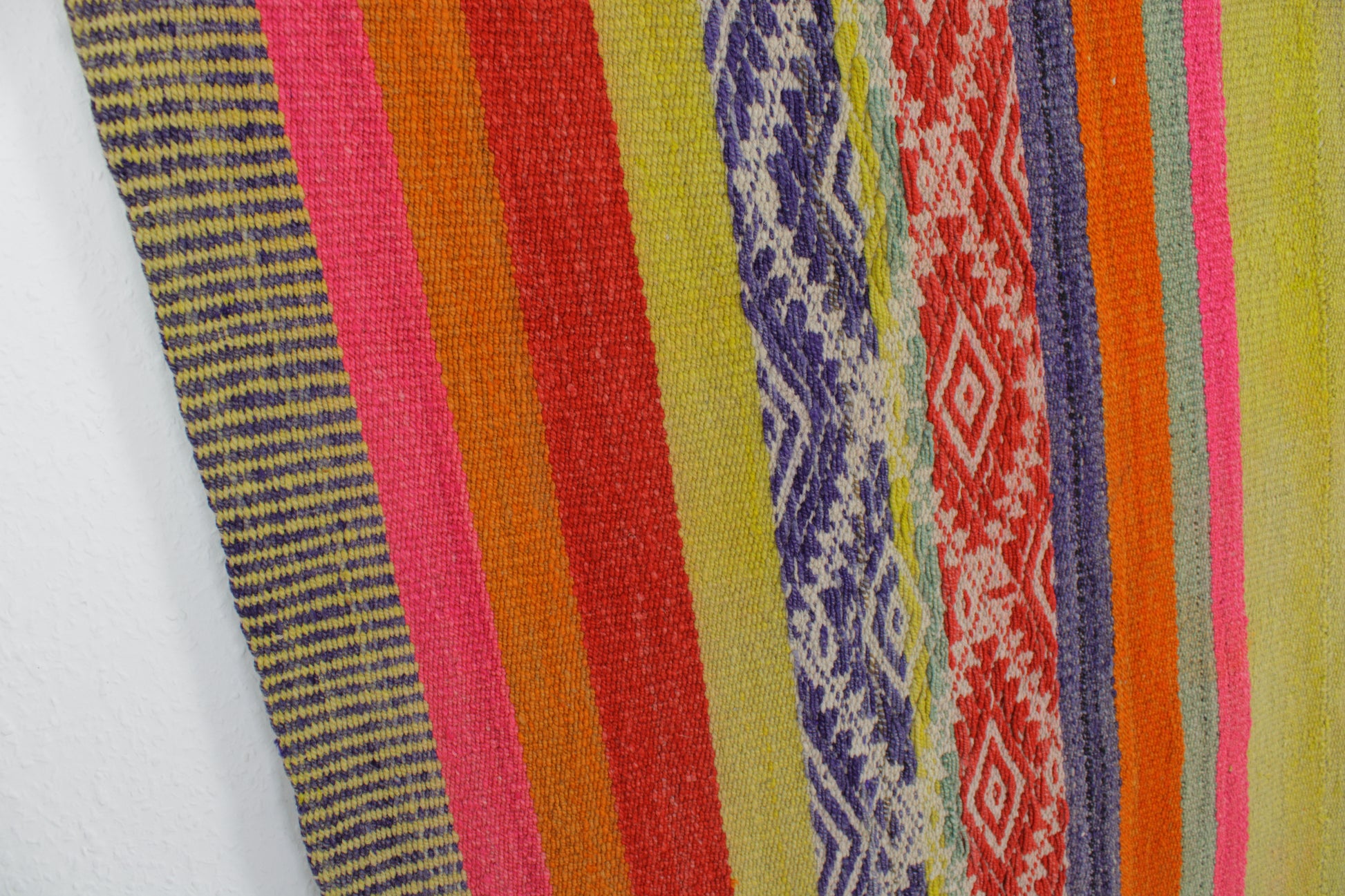 Handgefertigter Frazada-Teppich aus Peru – farbenfroh, traditionell und ideal für Balkon, Terrasse oder gemütliche Wohnräume. Dieser bunte Teppich bringt peruanisches Kunsthandwerk und Wärme in dein Zuhause und setzt lebendige Akzente im Boho- oder Ethno-Stil für drinnen und draußen.