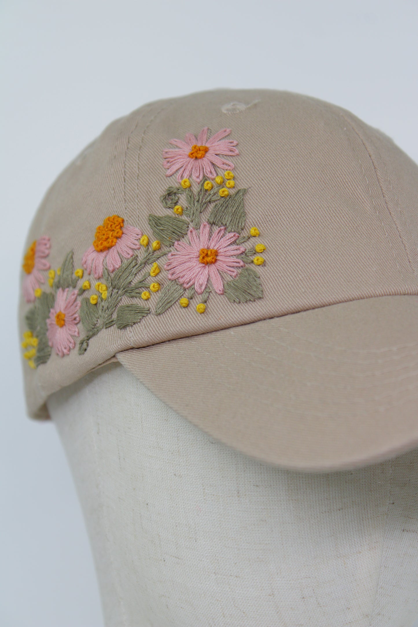 Handbestickte beige Cap von Glueck & Fund, modisches Accessoire mit kunstvoller Stickerei, zeigt stilvollen Casual-Look