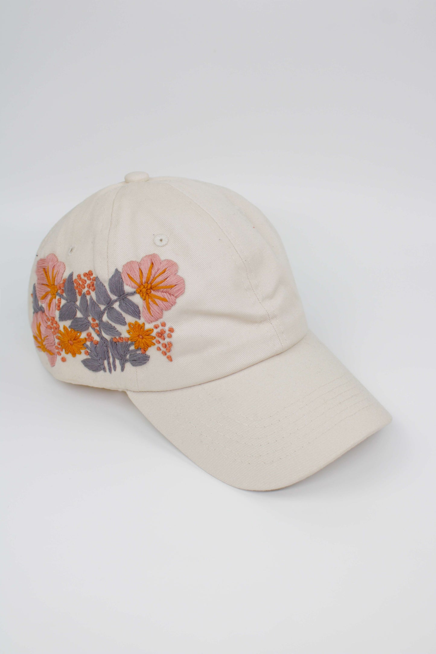 Handbestickte Cremeweiße Cap von Glueck & Fund, modisches Accessoire mit kunstvoller Stickerei, bequemes Kopfteil.