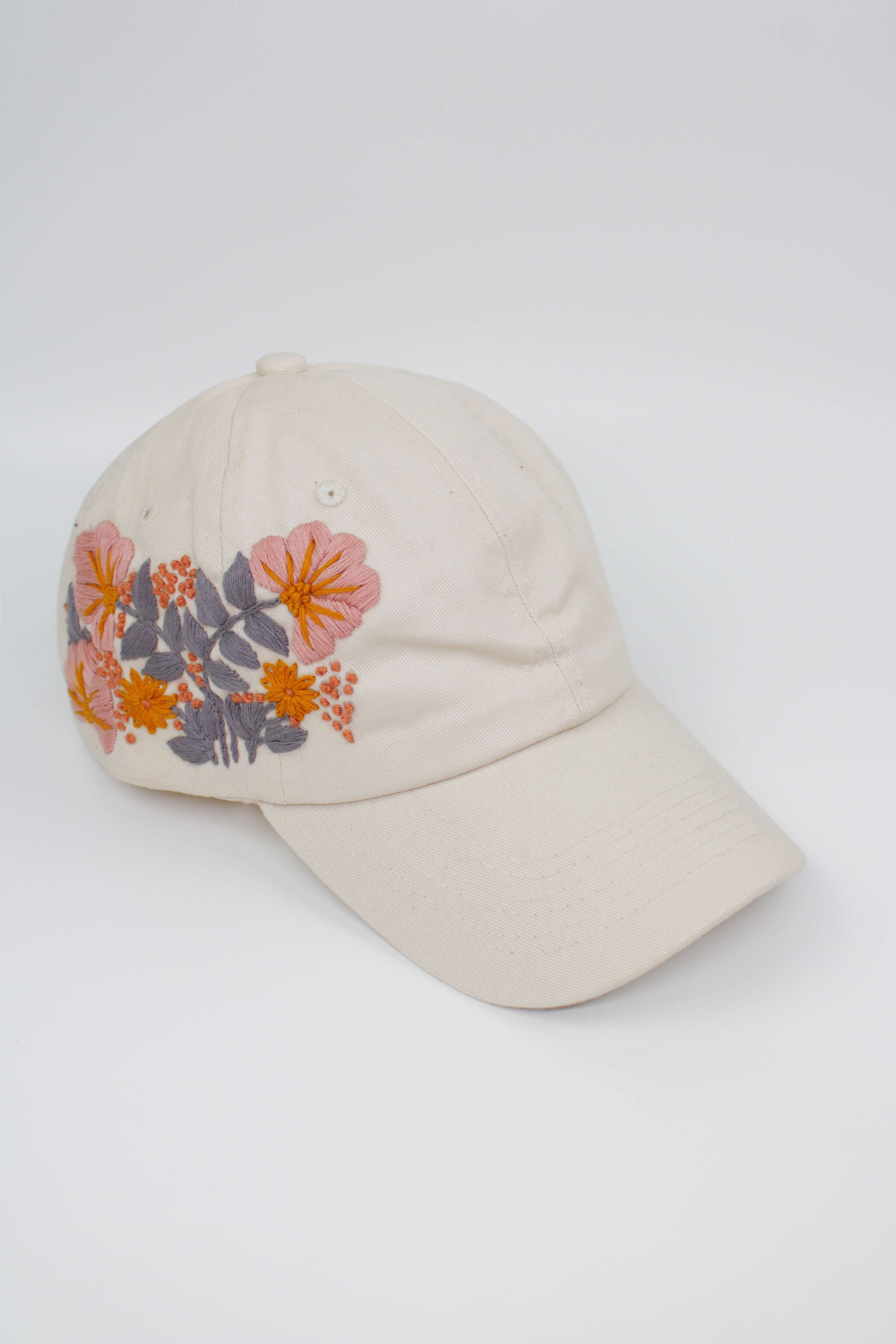 Handbestickte Cremeweiße Cap von Glueck & Fund, modisches Accessoire mit kunstvoller Stickerei, bequemes Kopfteil.