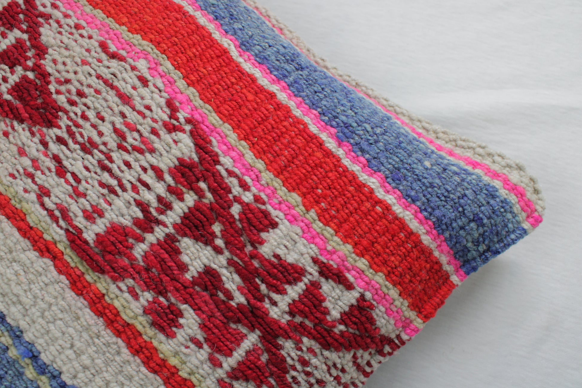 Blaue Frazadakissen 45x45 aus Peru von Glueck & Fund, weiches Kissen mit traditionellem Muster, auf einem Sofa liegend.