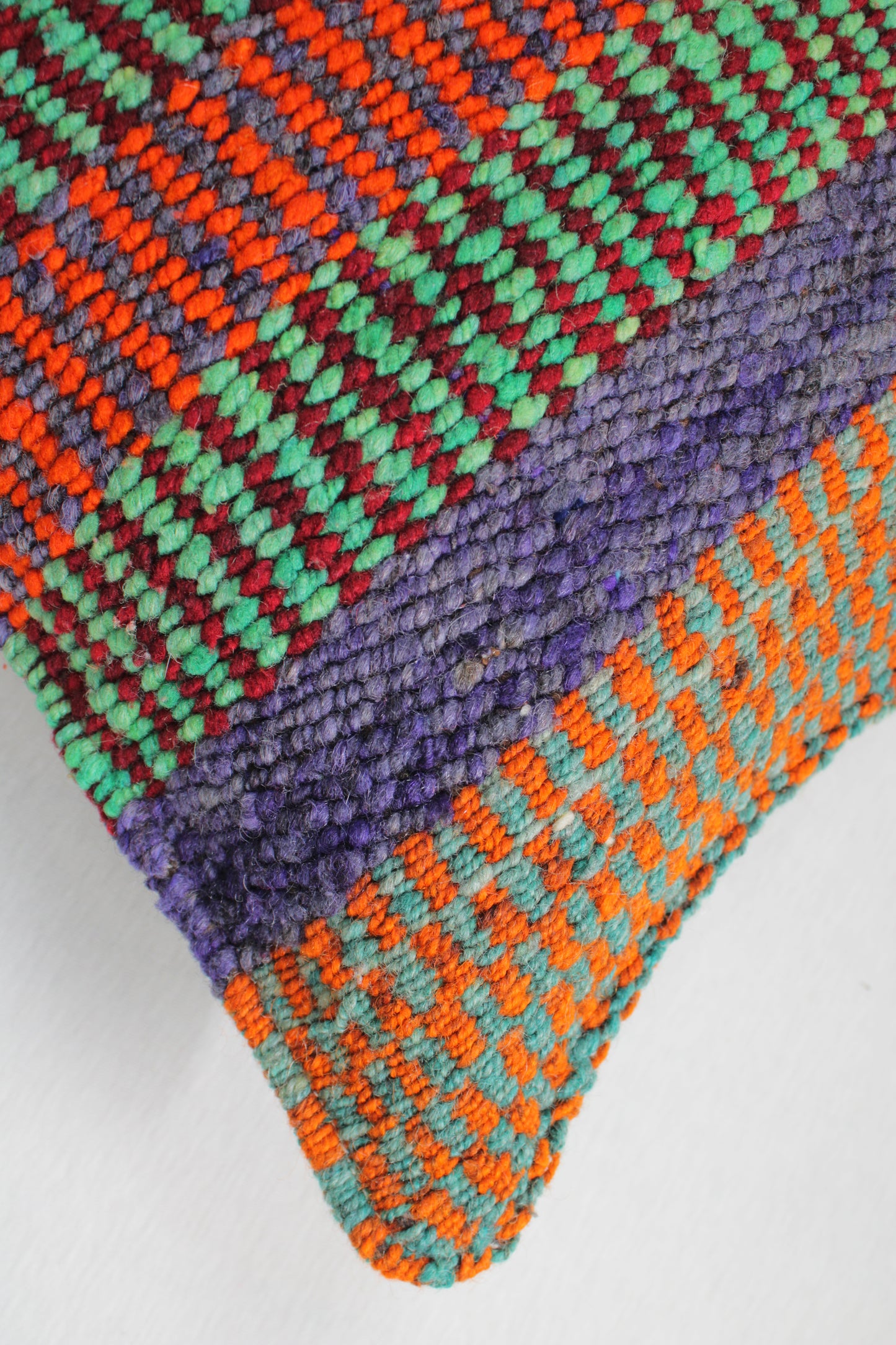 Grünes Frazadakissen 45x45 aus Peru von Glueck & Fund, weiche Textur und handgefertigtes Design, liegt auf einem Sofa.