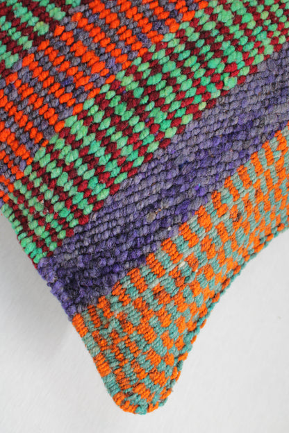 Grünes Frazadakissen 45x45 aus Peru von Glueck & Fund, weiche Textur und handgefertigtes Design, liegt auf einem Sofa.