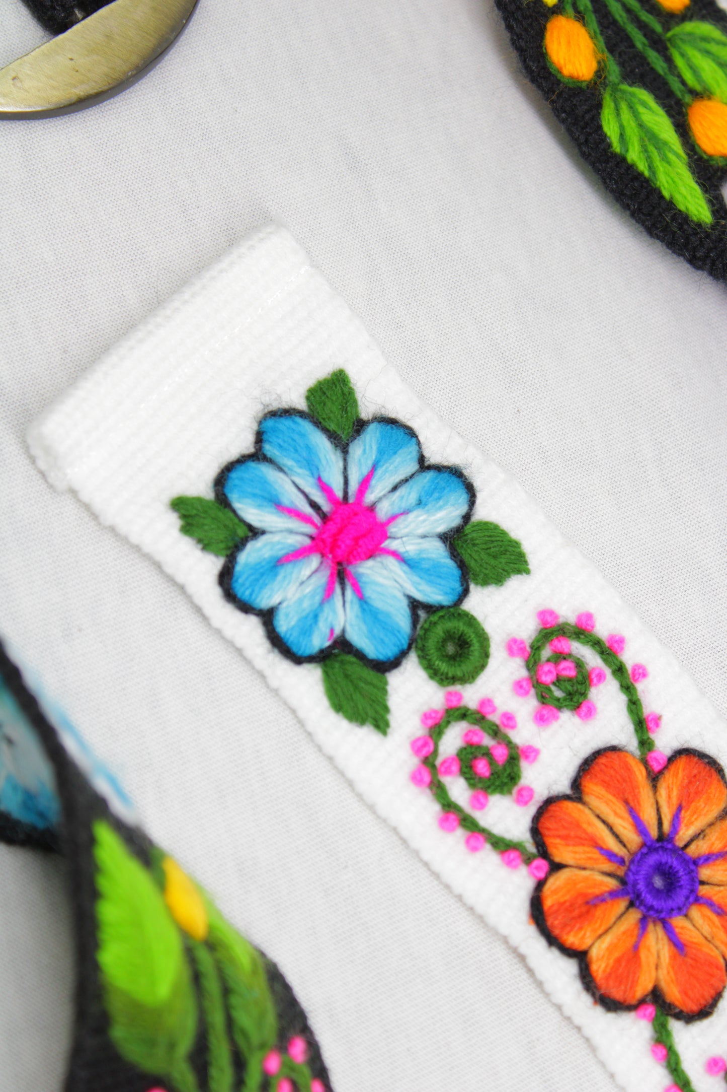 Handbestickter Ayacucho Gürtel von Glueck und Fund, aus Leder gefertigt mit kunstvollen Stickereien, auf einem weißen Hintergrund.