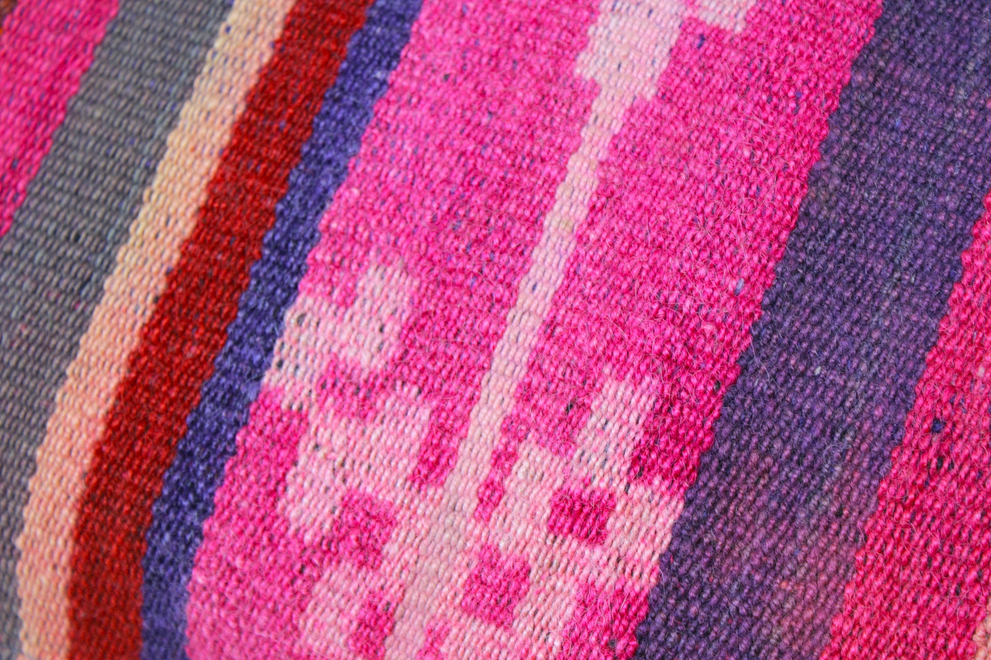 Buntes Frazadakissen 30x50 cm von Glueck und Fund in Magenta mit traditioneller Weboptik für gemütliche Sitzgelegenheiten.