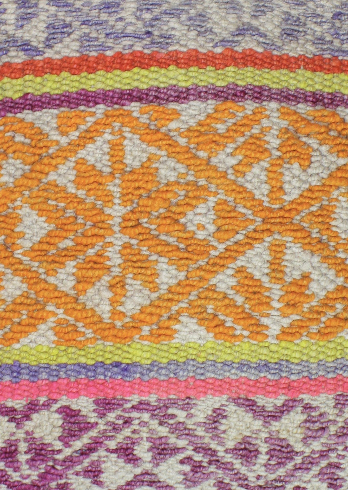 Dreifarbiges Frazadakissen 45x45 aus Peru mit Rautenmustern, von Glueck und Fund, auf einem stilvollen Sofa platziert.