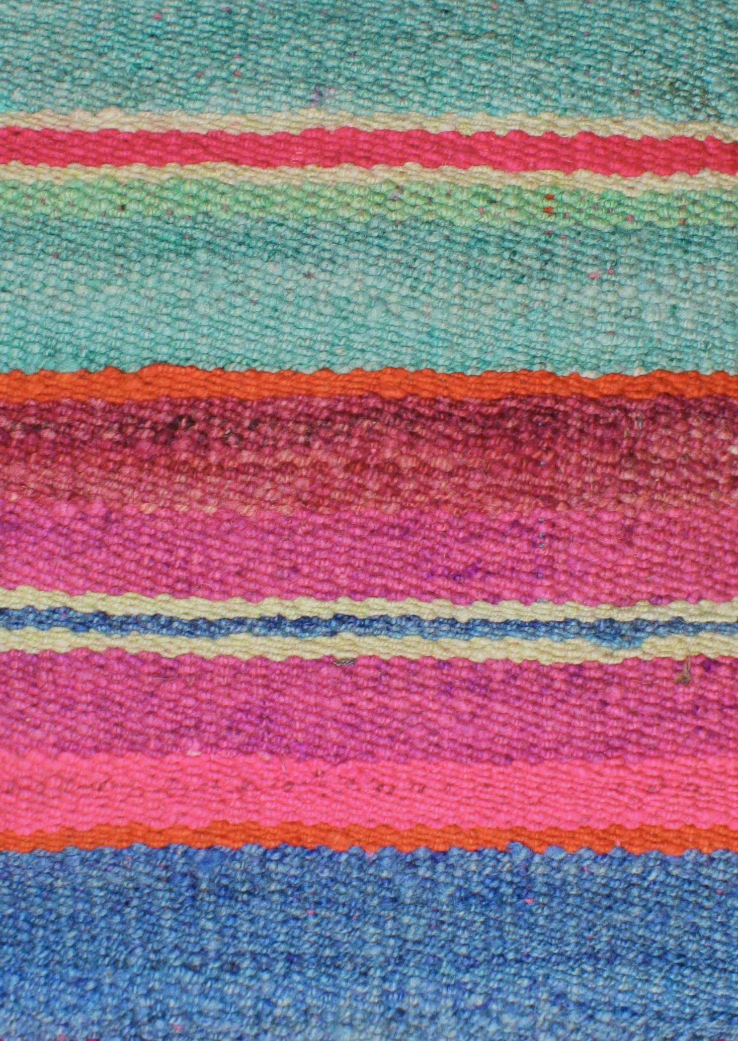 Leuchtendes blaues Frazadakissen 45x45 cm von Glueck und Fund, weiches Kissen mit buntem Muster auf hellgrauem Hintergrund