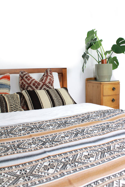 Handgewebte braune Boho Tagesdecke auf Bett von Glueck und Fund, einzigartiges Unikat, weiche Textur und stilvolles Design.