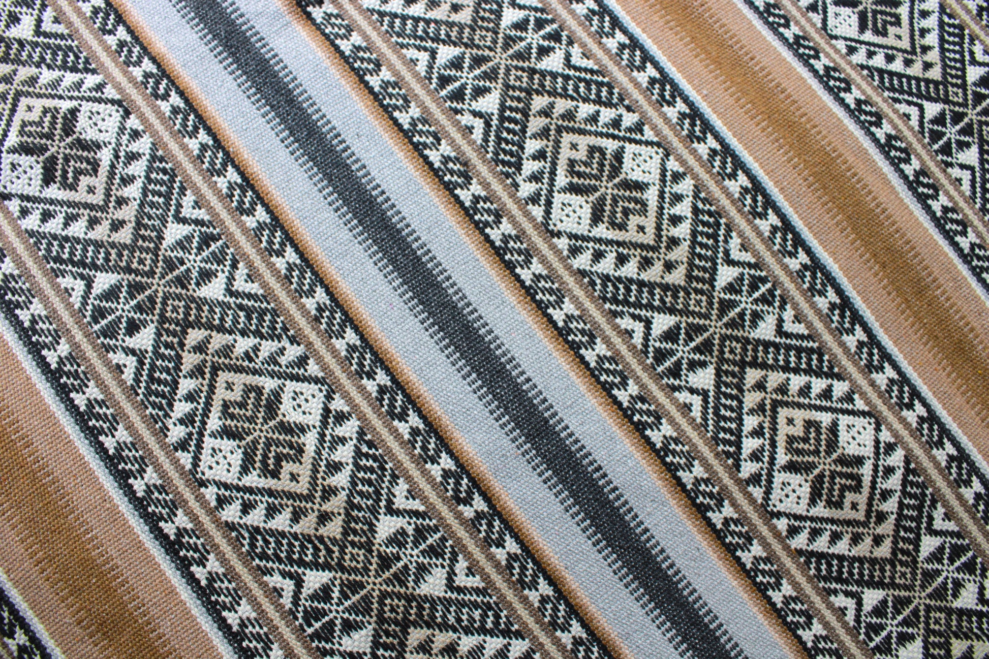 Detailansicht braune Boho Tagesdecke als Unikat von Glueck und Fund, zeigt detaillierte Webmuster und weiche Textur.